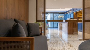 Un vestíbulo moderno con zona de estar, un mostrador de recepción y vistas al área de la cocina.