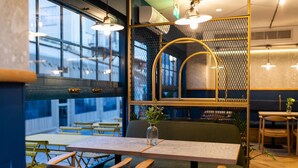 Interior de restaurante con una mesa, sillas y un jarrón decorativo.