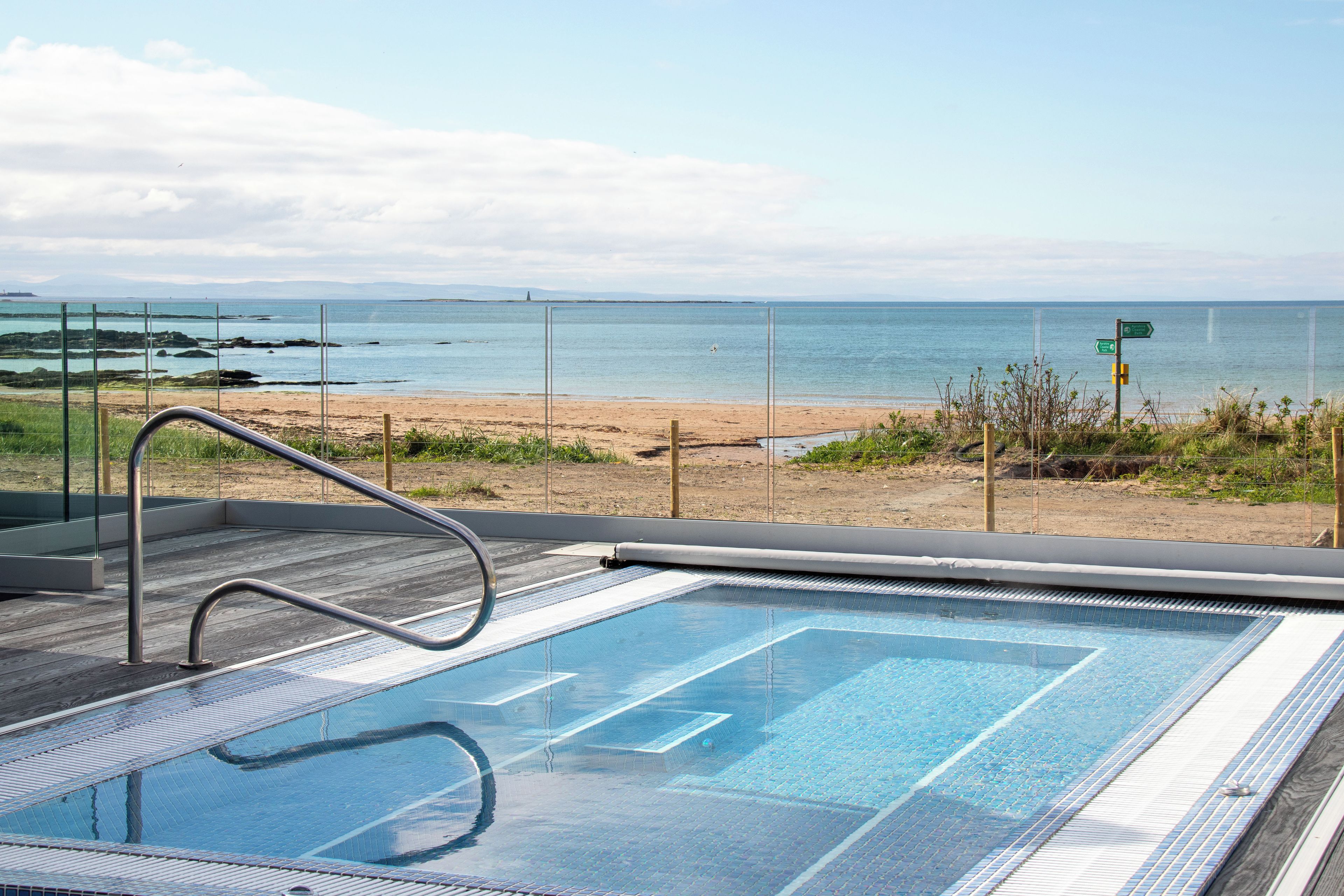 A swimming pool with a view of the beach and ocean.