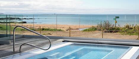 Una piscina con vistas a la playa y al océano.