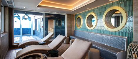 A sunlit room with lounge chairs, a wall-mounted circular mirror, and a view of the outdoors.