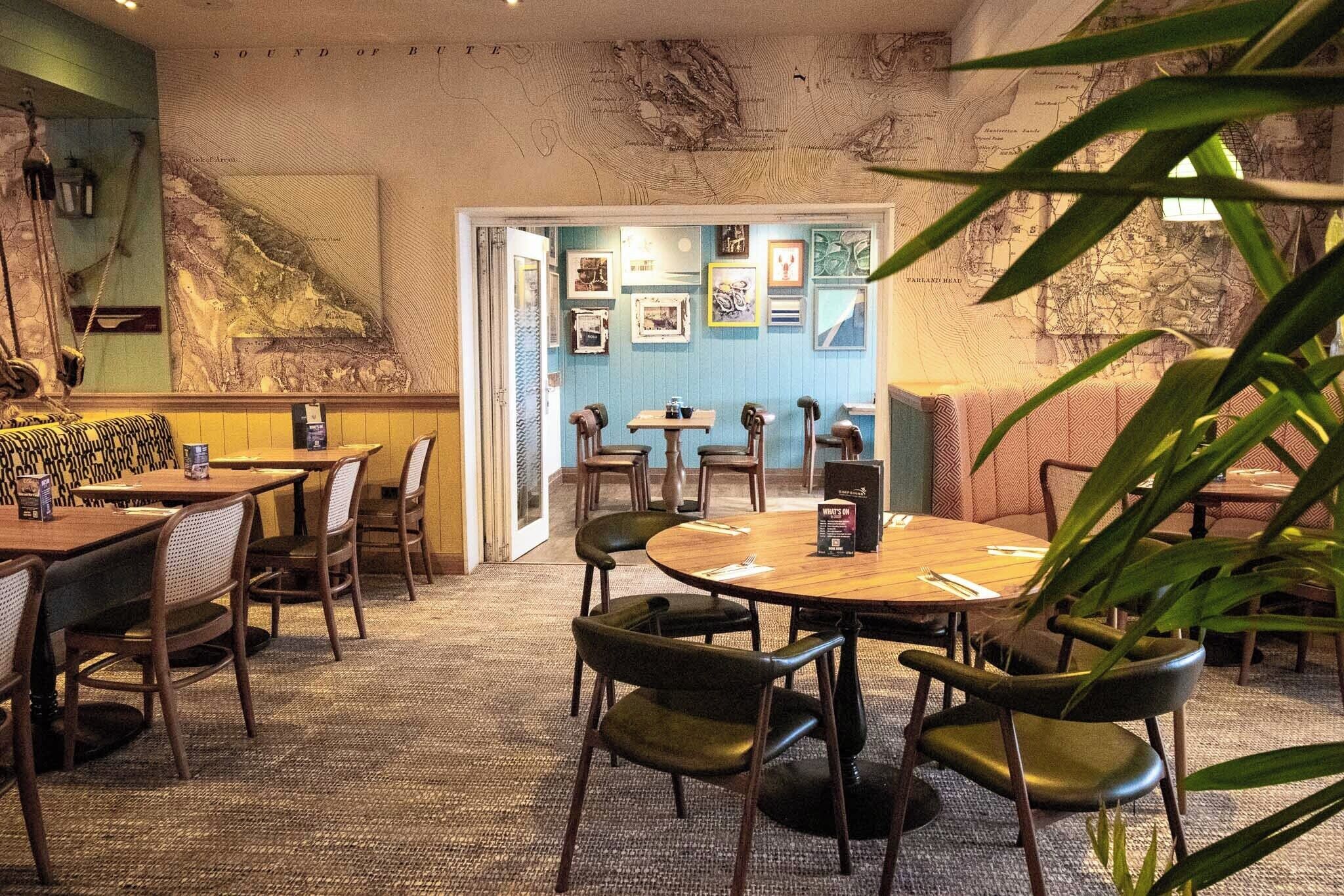 A restaurant with a nautical theme, featuring a large map on the wall and several tables and chairs.