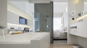 A modern bathroom with a large bathtub, a shower, and a vanity with a mirror. - Swiio Hotel Daan (Taipei)