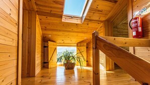 A wooden interior with a skylight, a staircase, and a potted plant. - A Casa do Tio Tenente (Serta)