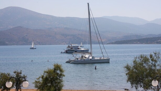 A lake with sailboats and a beach in the foreground. - Aura Boutique Hotel (Kefalonia)
