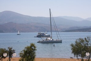 A lake with sailboats and a beach in the foreground. - Aura Boutique Hotel (Kefalonia)