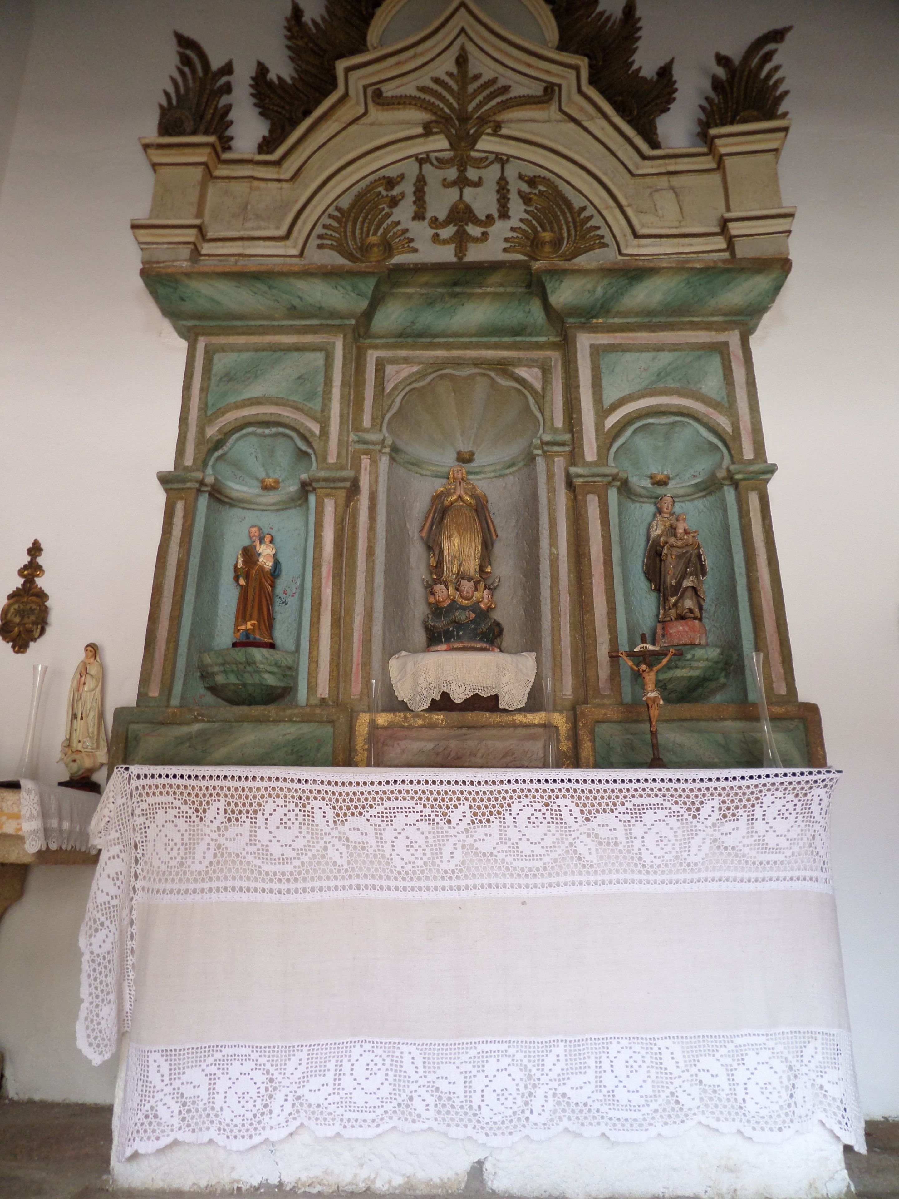 A religious altar with statues and a lace cloth.