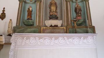 A religious altar with statues and a lace cloth.
