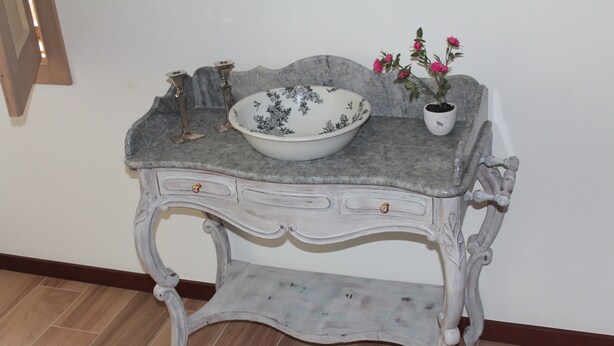 Una mesa de estilo antiguo con un cuenco y una planta en maceta.