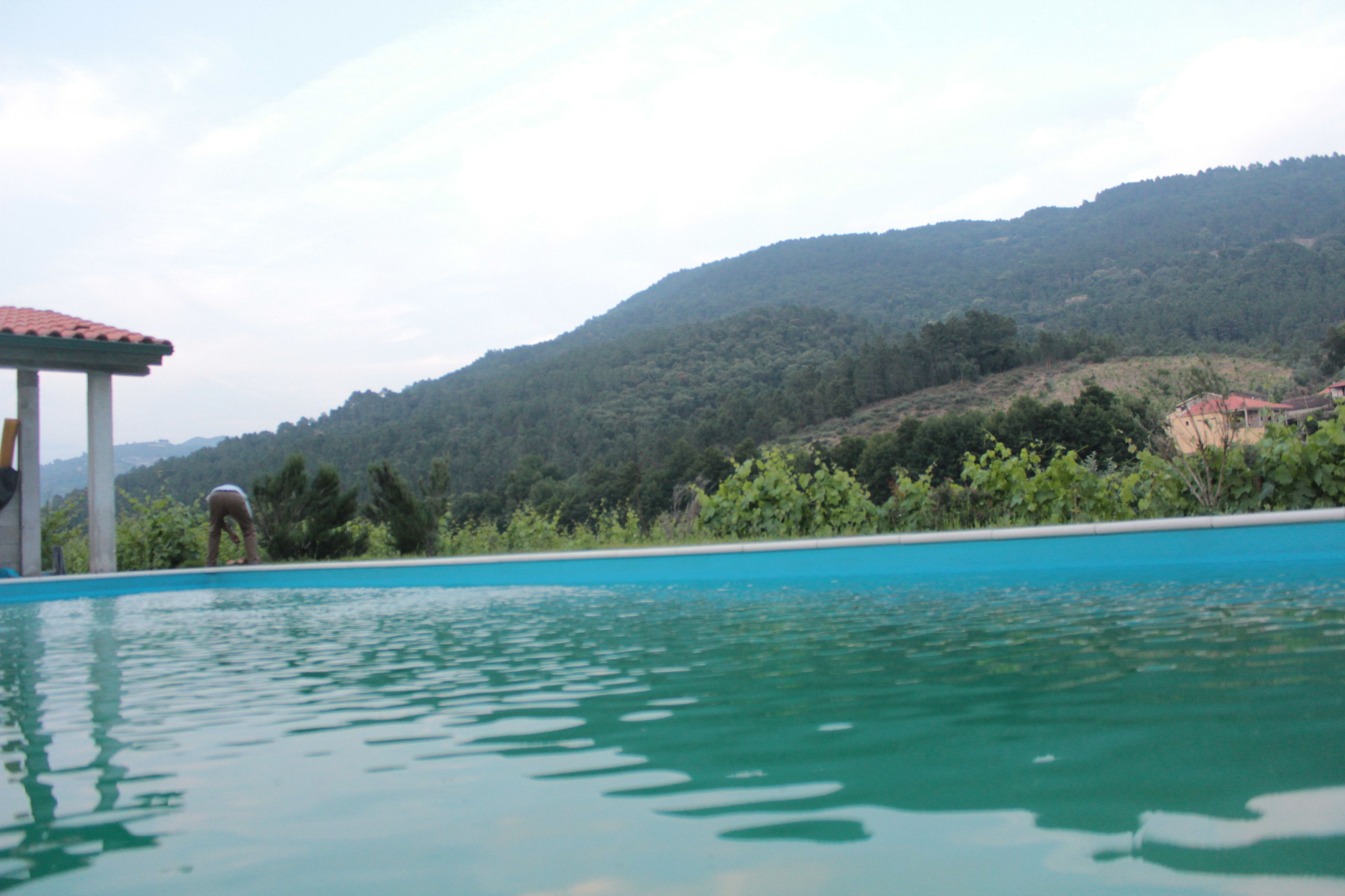 Una piscina con una vista despejada de un paisaje montañoso al fondo.