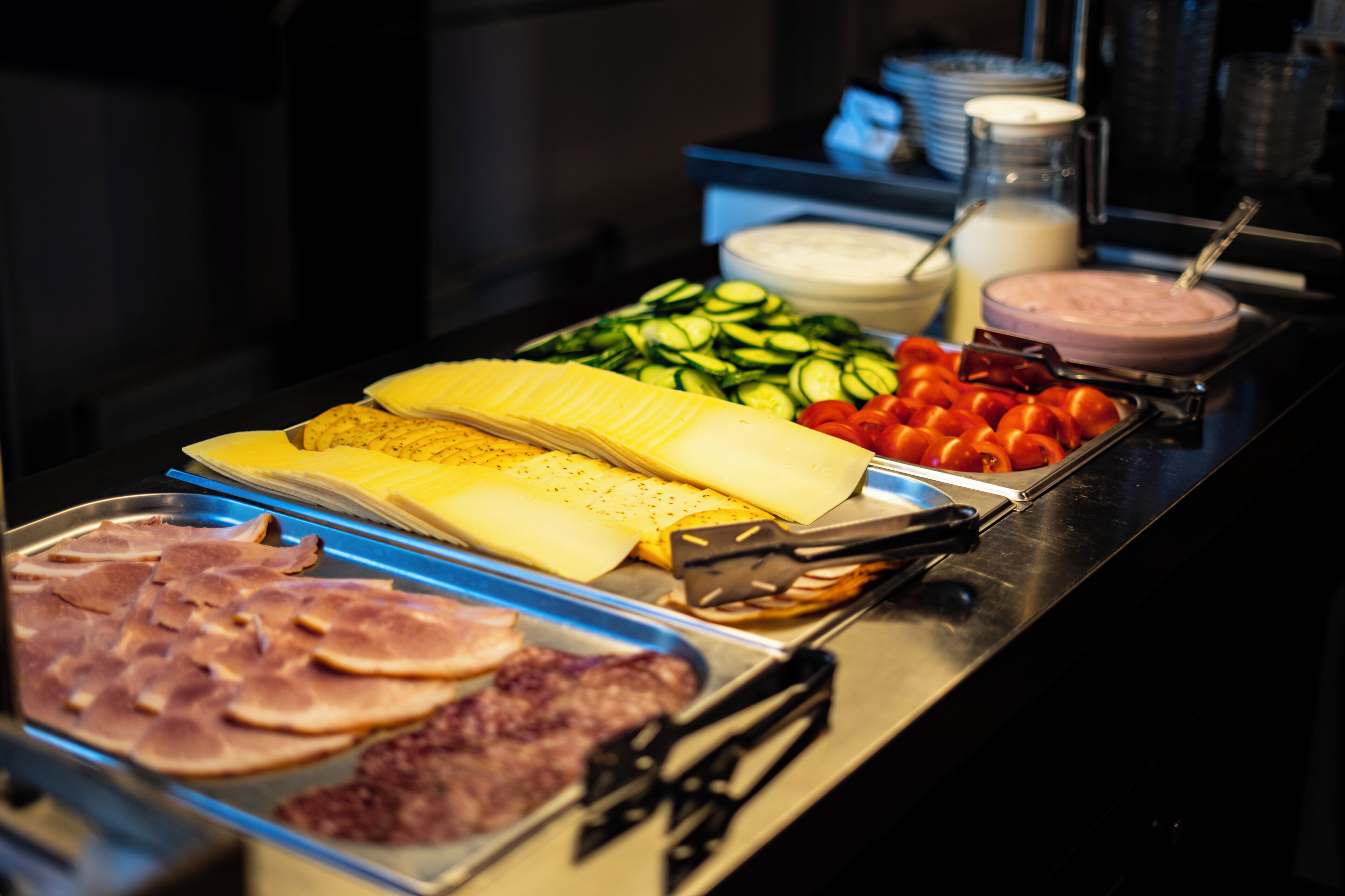 Un buffet proposant une variét é de plats, notamment des viandes, des fromages, des légumes et des sauces.