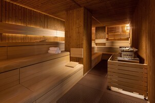 Uma sauna com bancos de madeira e uma pequena mesa com toalhas.