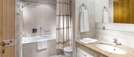 A modern bathroom with a bathtub, toilet, and sink.