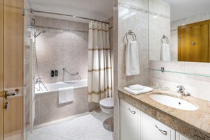 Un bagno moderno con vasca, servizi igienici e lavandino.