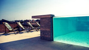 A rooftop pool area with lounge chairs and a clear view of the city skyline. - Lokàl Boutique Hotel (Larnaca)
