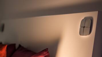 A close-up of a wall with a recessed light fixture and a small, modern control panel.
