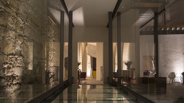A modern interior with a glass floor, stone walls, and a staircase. - Lokàl Boutique Hotel (Larnaca)