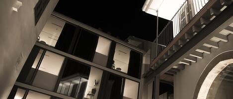 A multi-level building with balconies and staircases, featuring modern architecture and interior lighting.