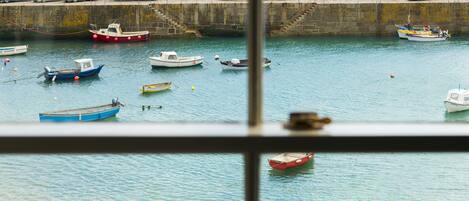 A harbor with various boats docked and a stone wall in the background.