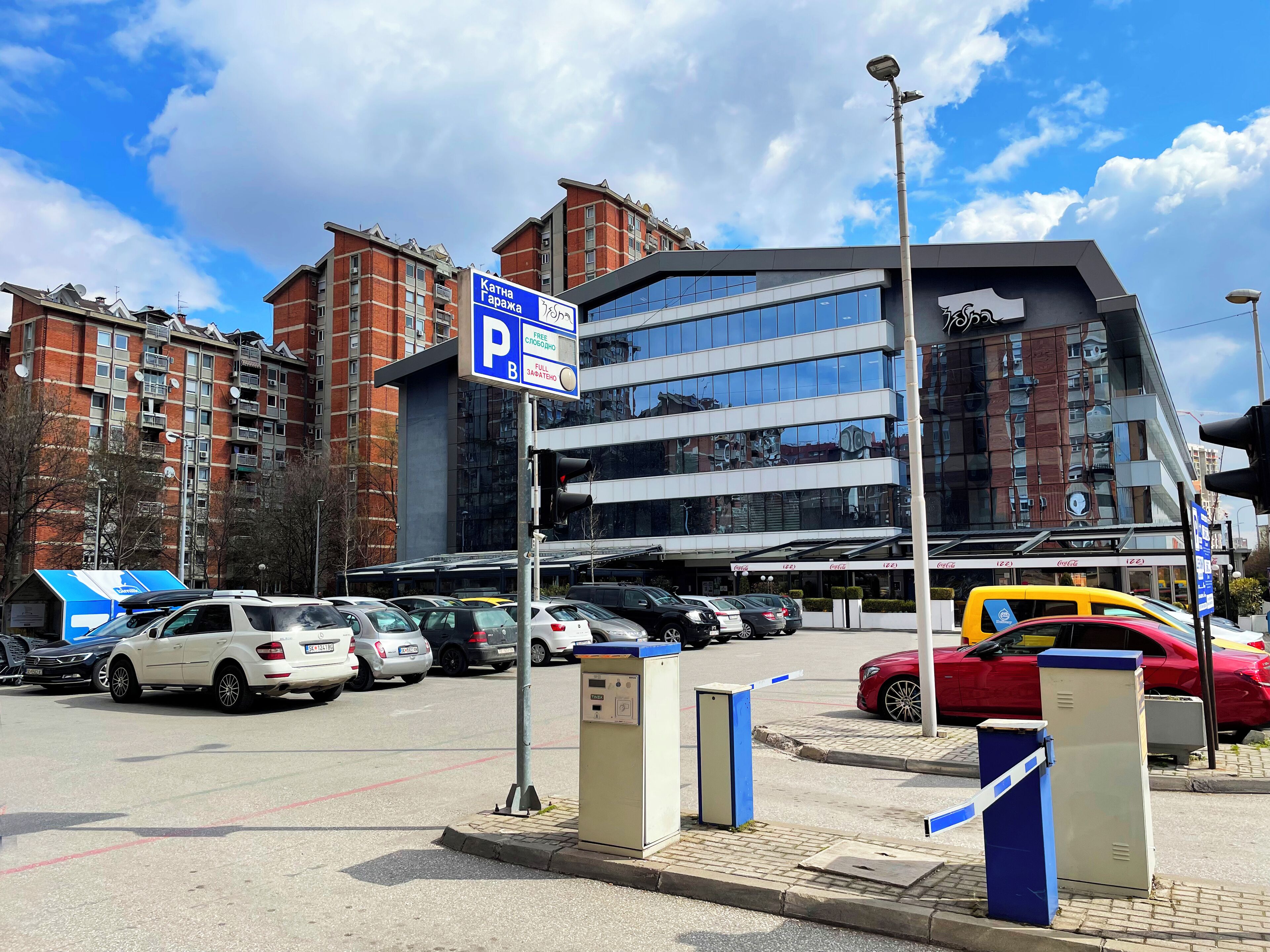Un área de estacionamiento con un cartel que indica estacionamiento gratuito y una estancia completa de 3 horas.