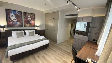 Un dormitorio moderno con una cama grande, un escritorio y un armario.