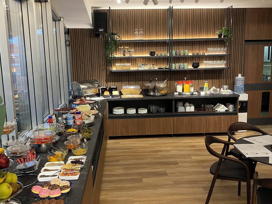 A buffet setup with various food items and a seating area with chairs.