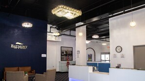 Un área de recepción con el letrero de Baymont Inn & Suites, un mostrador de recepción, un reloj y un cuadro en la pared.