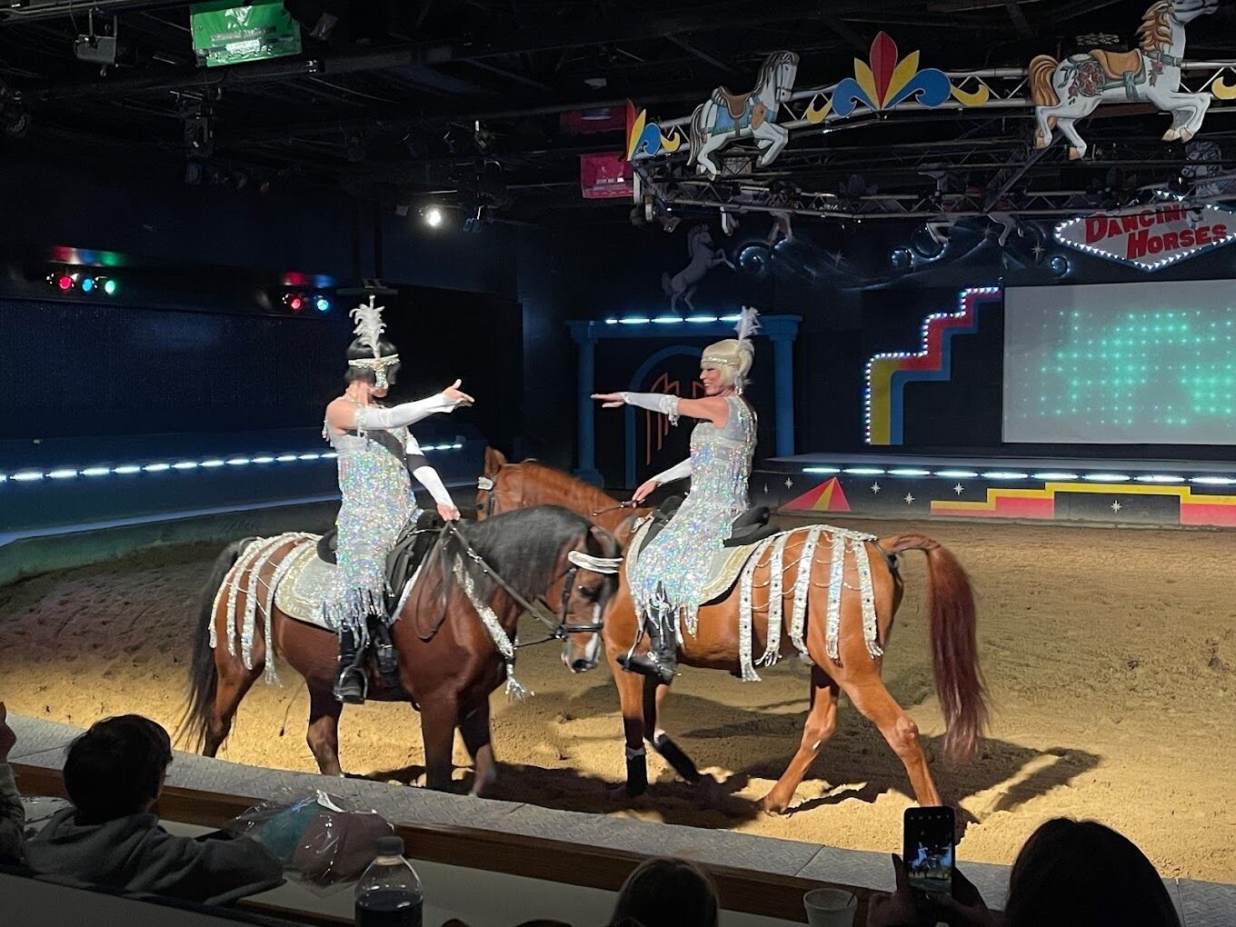 Een optreden met twee ruiters op paarden in een circushaard.