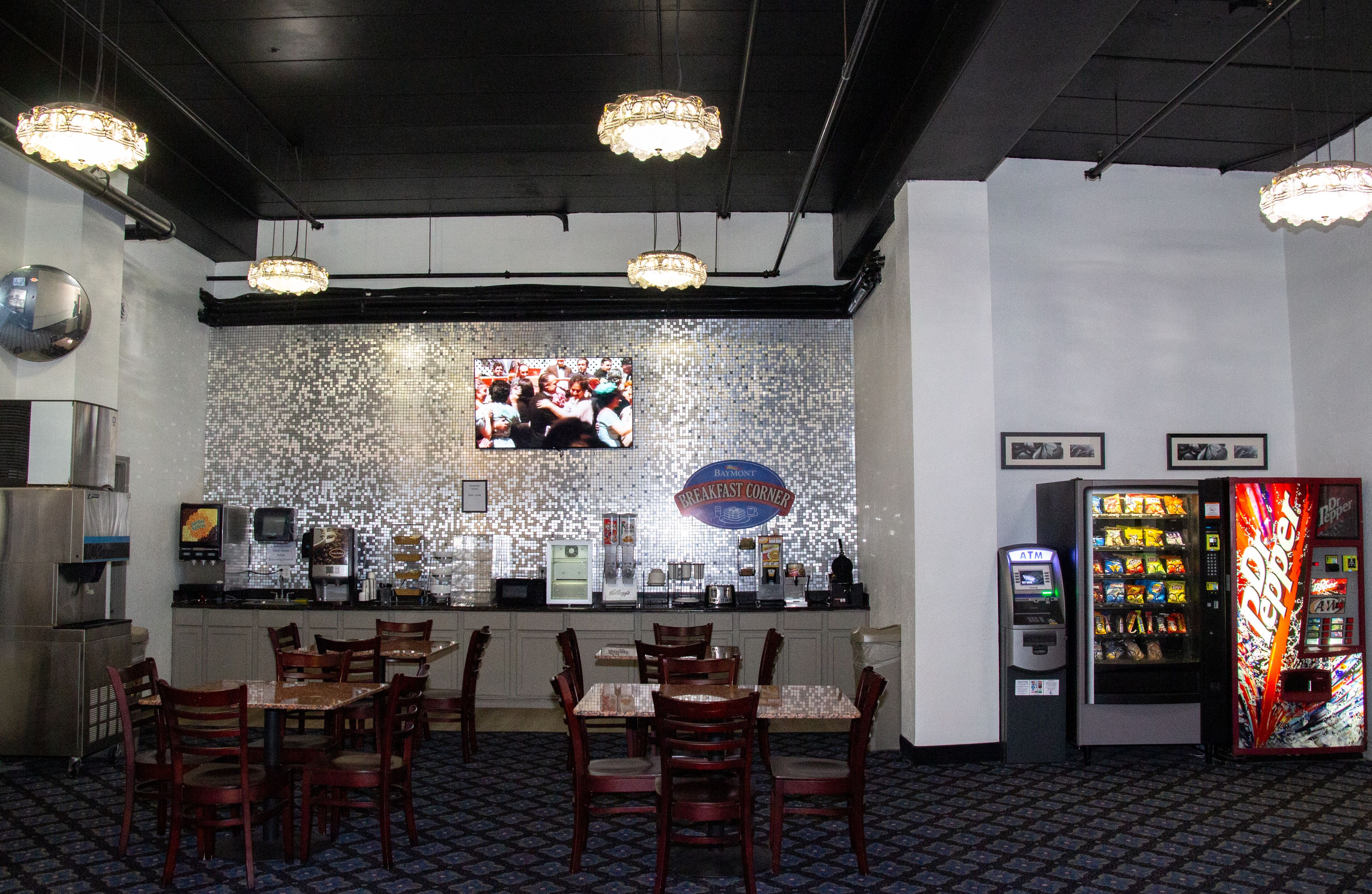 A restaurant with a bar area, seating, and a vending machine.
