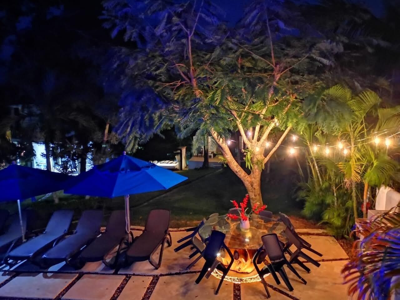 An outdoor seating area with a round table, chairs, and a fire pit.