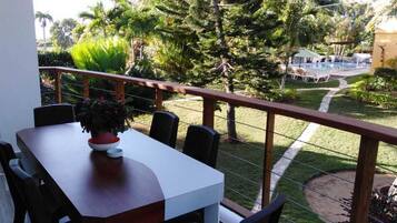 Enjoy a peaceful retreat with a balcony overlooking the pool and lush surroundings.