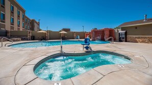 A hotel pool area with multiple pools, lounge chairs, and umbrellas. - Comfort Suites Kanab National Park Area (Kanab)