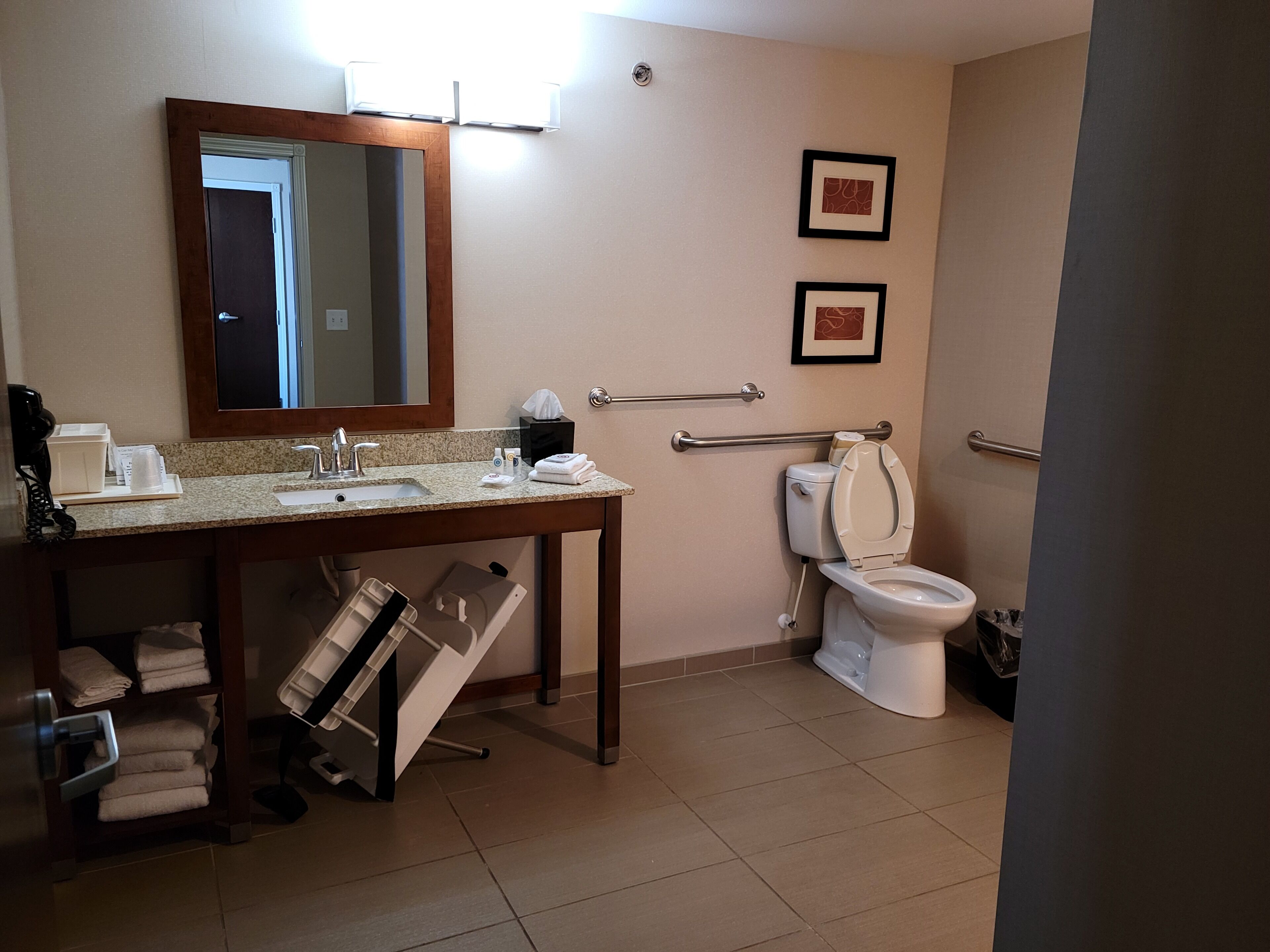 A bathroom with a sink, mirror, toilet, and towel rack.