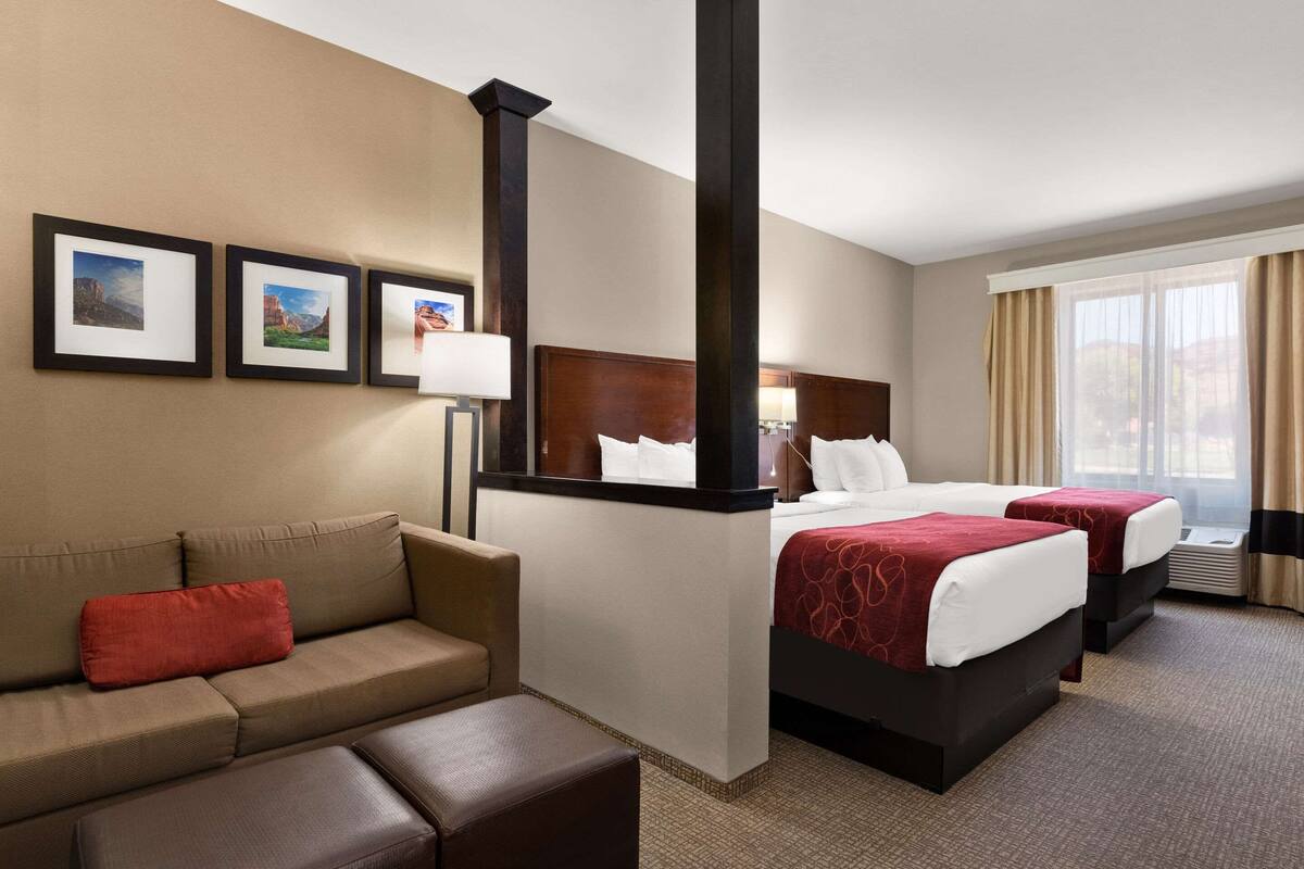 Ein Hotelzimmer mit einem Bett, einer Couch und einem großen Fenster.