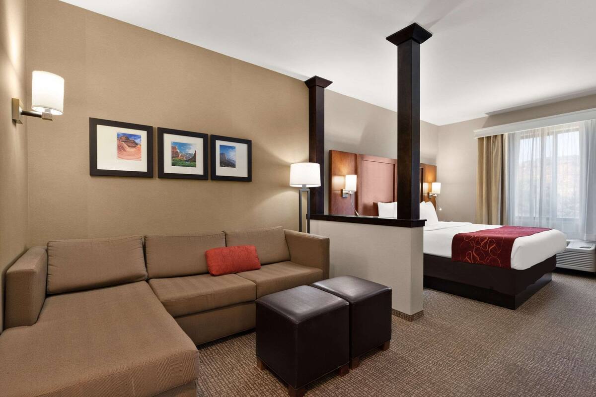 Ein Hotelzimmer mit einem Bett, einer Couch, einem Couchtisch und Wandbildern.