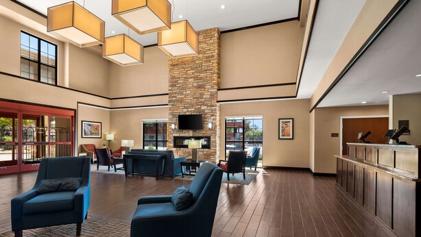 A spacious lobby with a stone fireplace, comfortable seating, and a reception desk. - Comfort Suites Kanab National Park Area (Kanab)