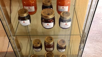 A display case with various jars of marmalade labeled with names and prices.