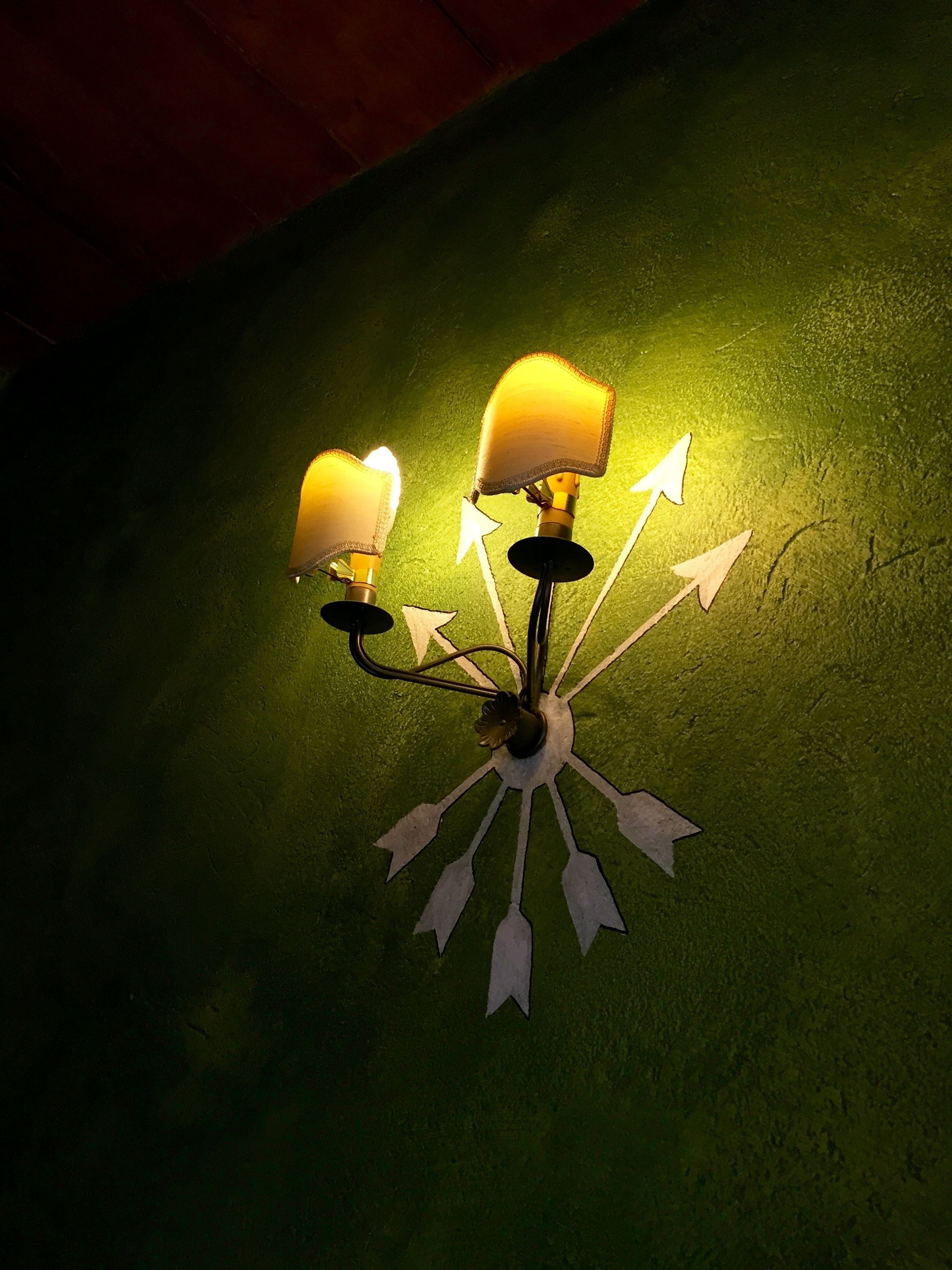 Una lámpara de pared con dos luces y varias flechas direccionales.