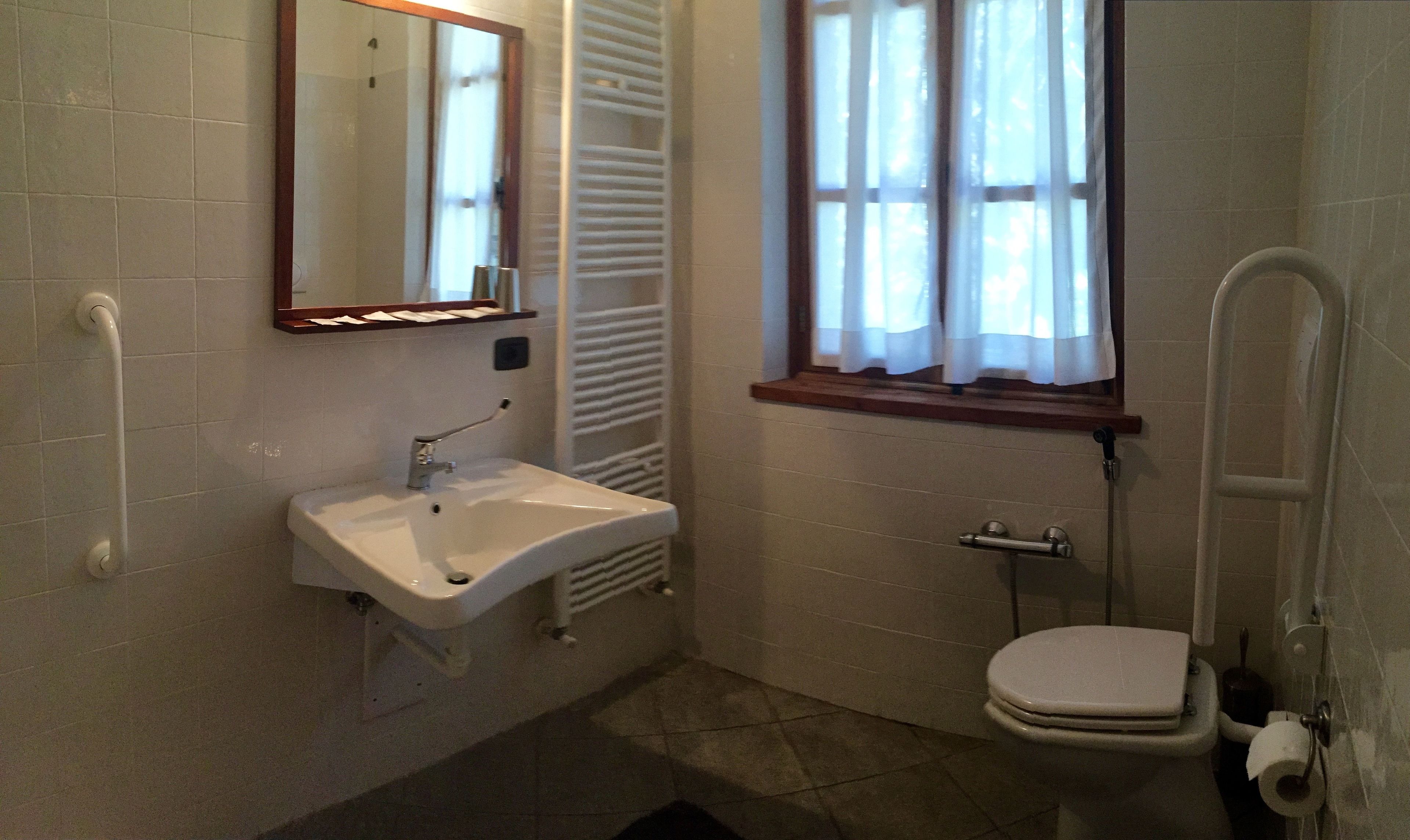 Un baño con lavabo, inodoro y ventana.
