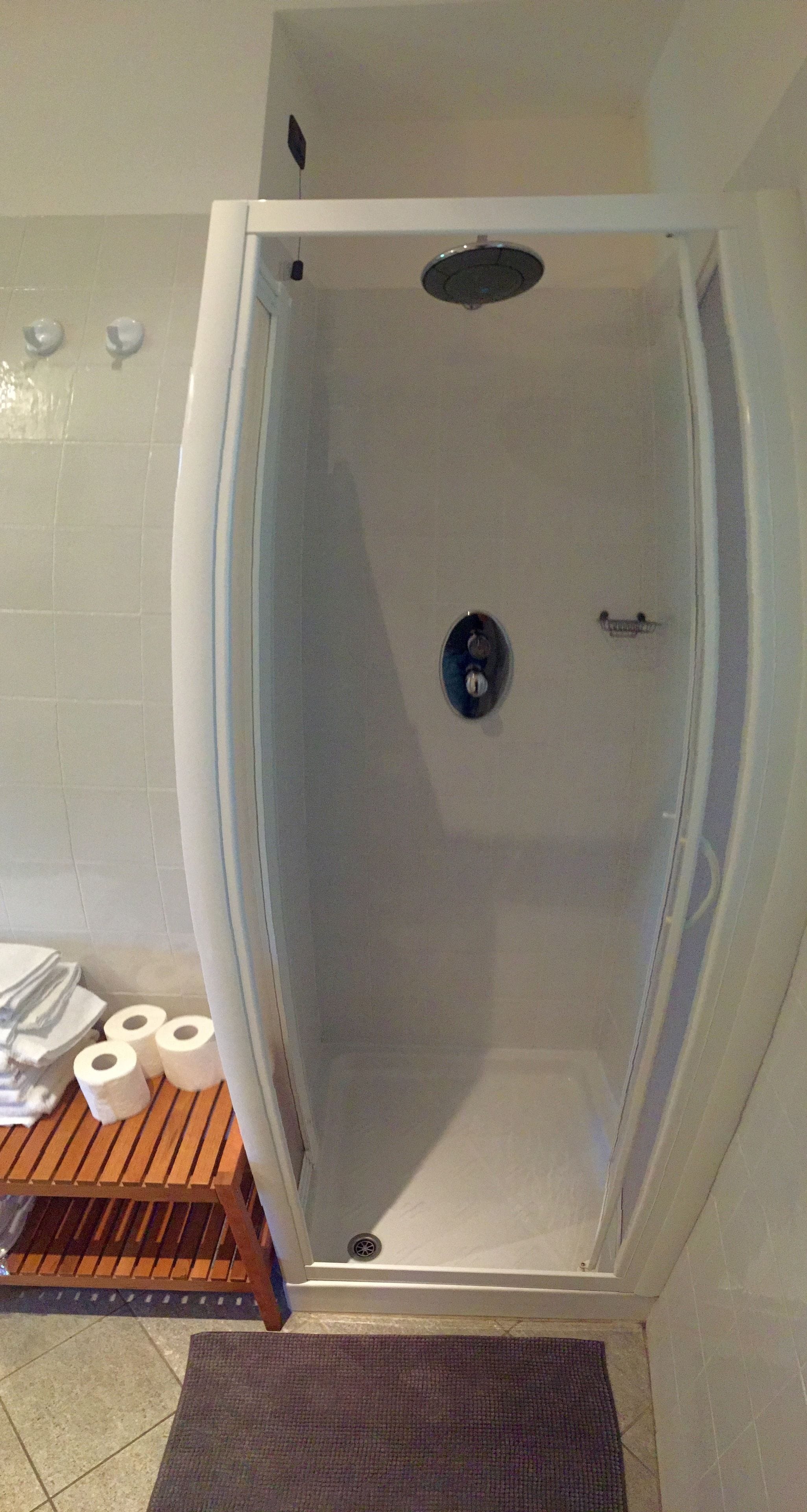 Een badkamer met een douche, toilet en wastafel.