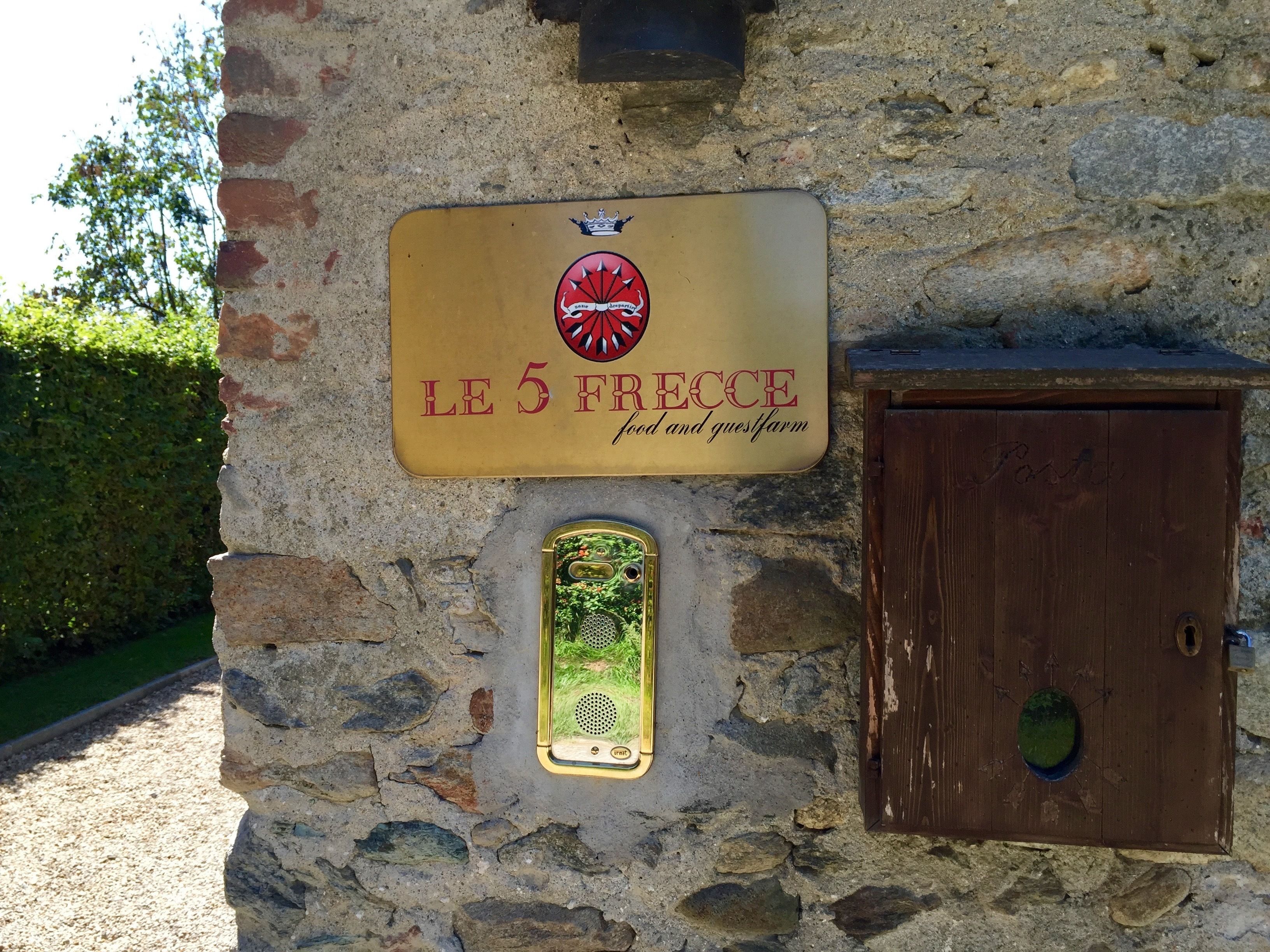 Een stenen gebouw met een bord waarop staat: LE 5 FRECCE food and guestfarm.
