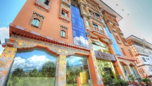 Un edificio con detalles arquitectónicos intrincados, una fachada de vidrio destacada y un letrero que dice "NANASELLING".