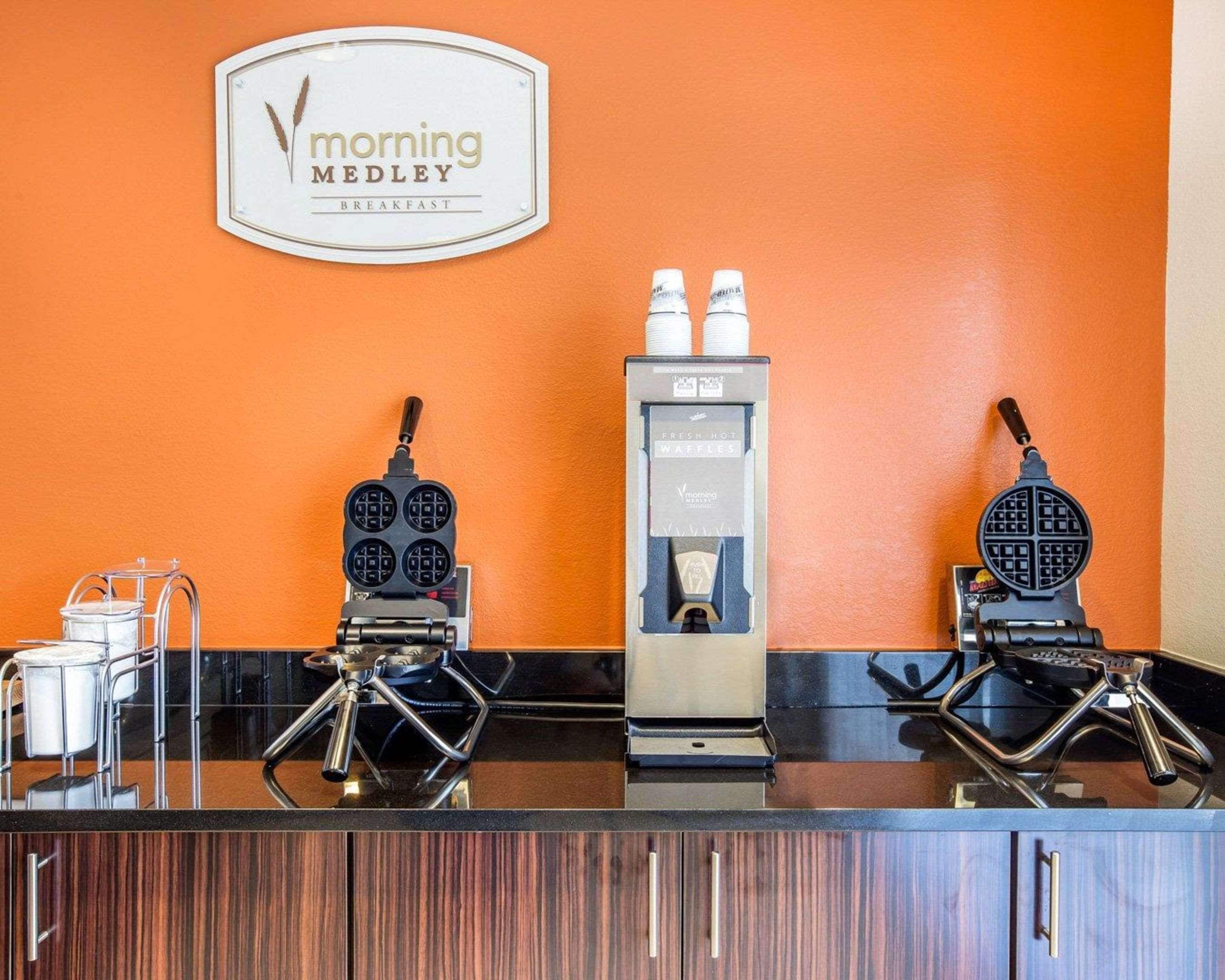 A breakfast station with two waffle makers, a coffee machine, and a sign for 'Morning Medley Breakfast'.