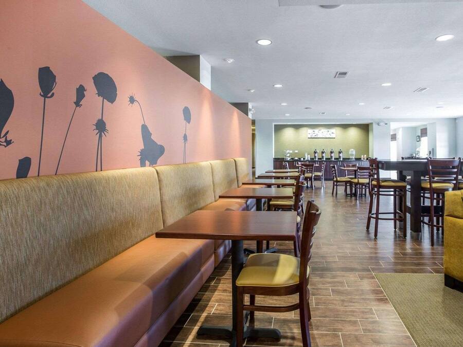 A restaurant with booths and tables, a counter with a menu, and a wall with floral designs.
