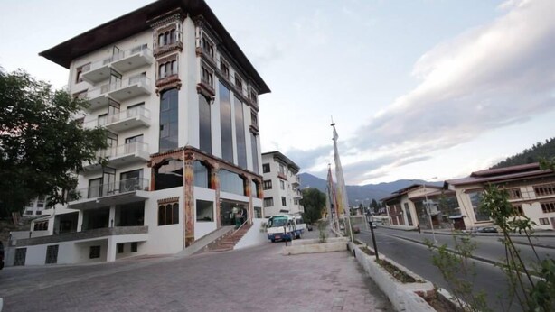 Un edificio a più piani con balconi, una scala centrale e un'antenna.