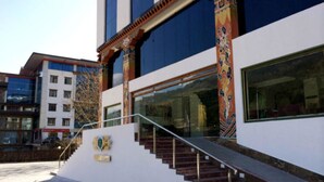 A building with a modern facade, a staircase leading to the entrance, and a large window.