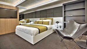 Un dormitorio moderno con una cama grande, mesitas de noche, una silla y estanterías empotradas.