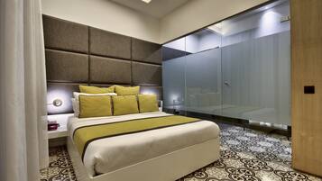 Un dormitorio moderno con una cama grande, cabecero, armario y suelo estampado.