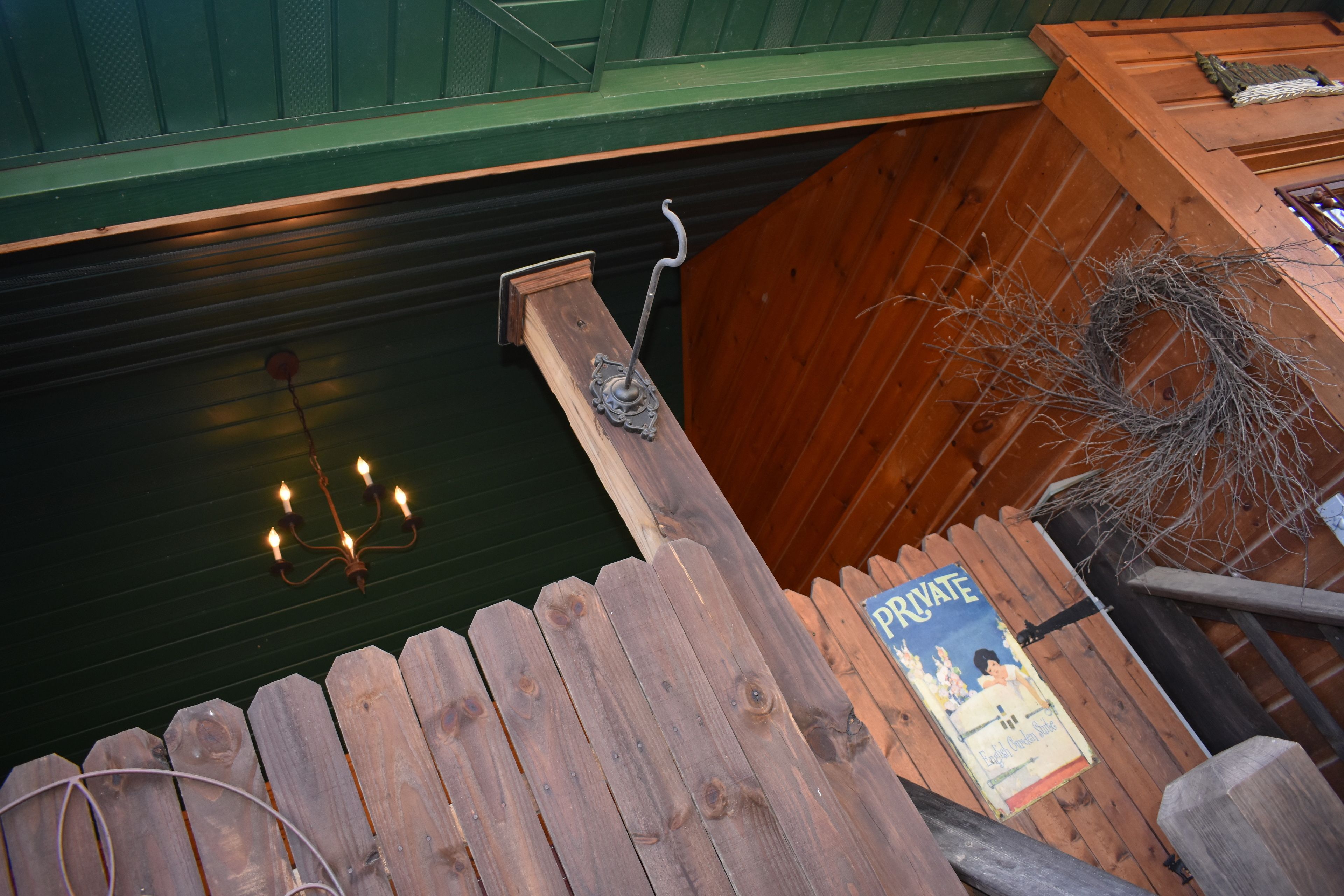 A wooden staircase with a rustic design, a chandelier, and a sign indicating the space is private.