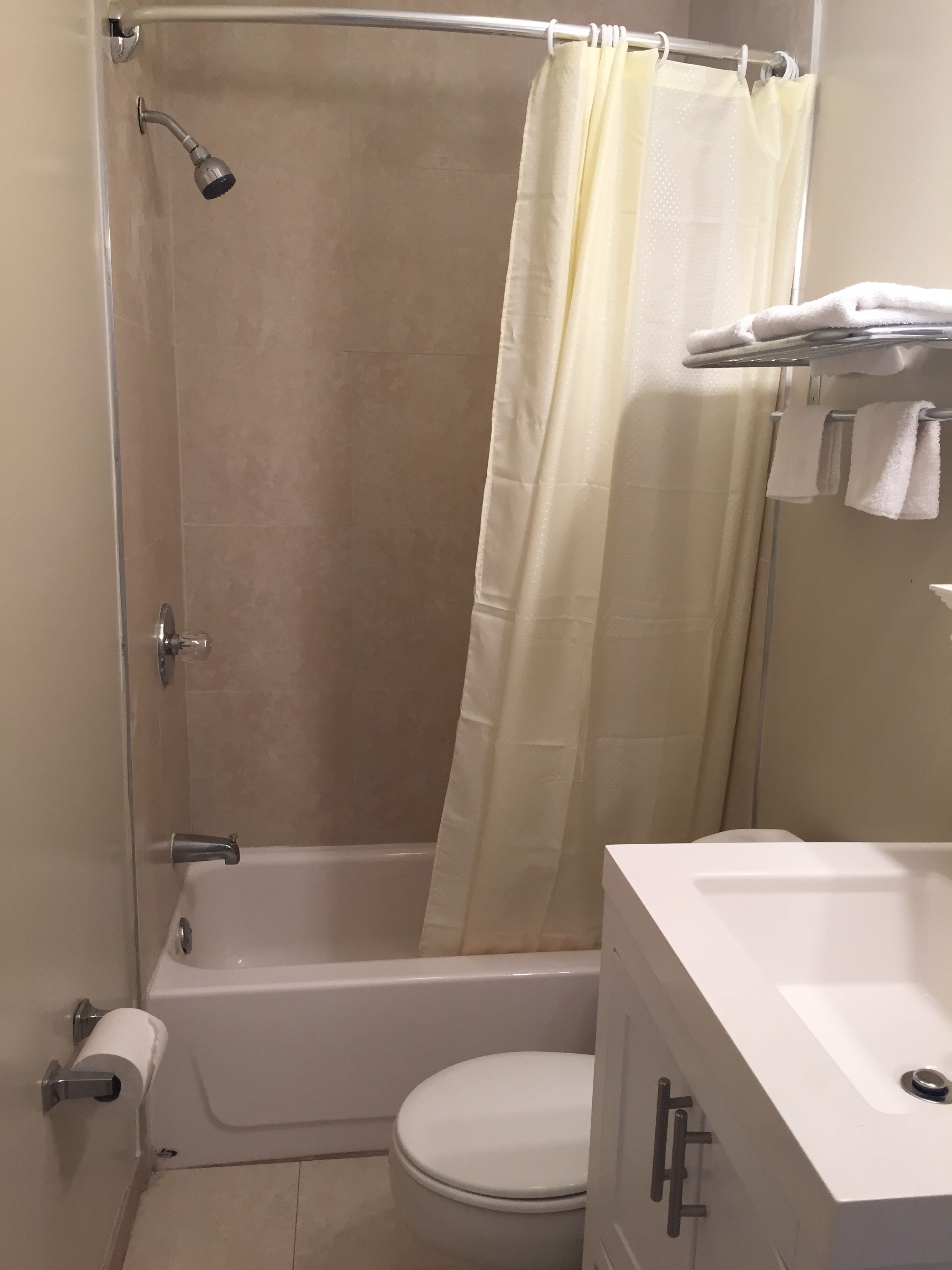 Un baño con bañera, inodoro y cortina de ducha.